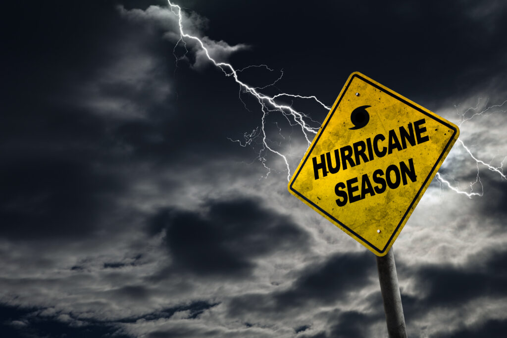 Hurricane season with symbol sign against a stormy background and copy space. Dirty and angled sign adds to the drama.
